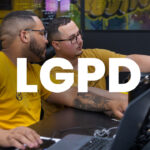 Profissional organizando contatos no celular e computador, representando a aplicação da LGPD para pequenas empresas.