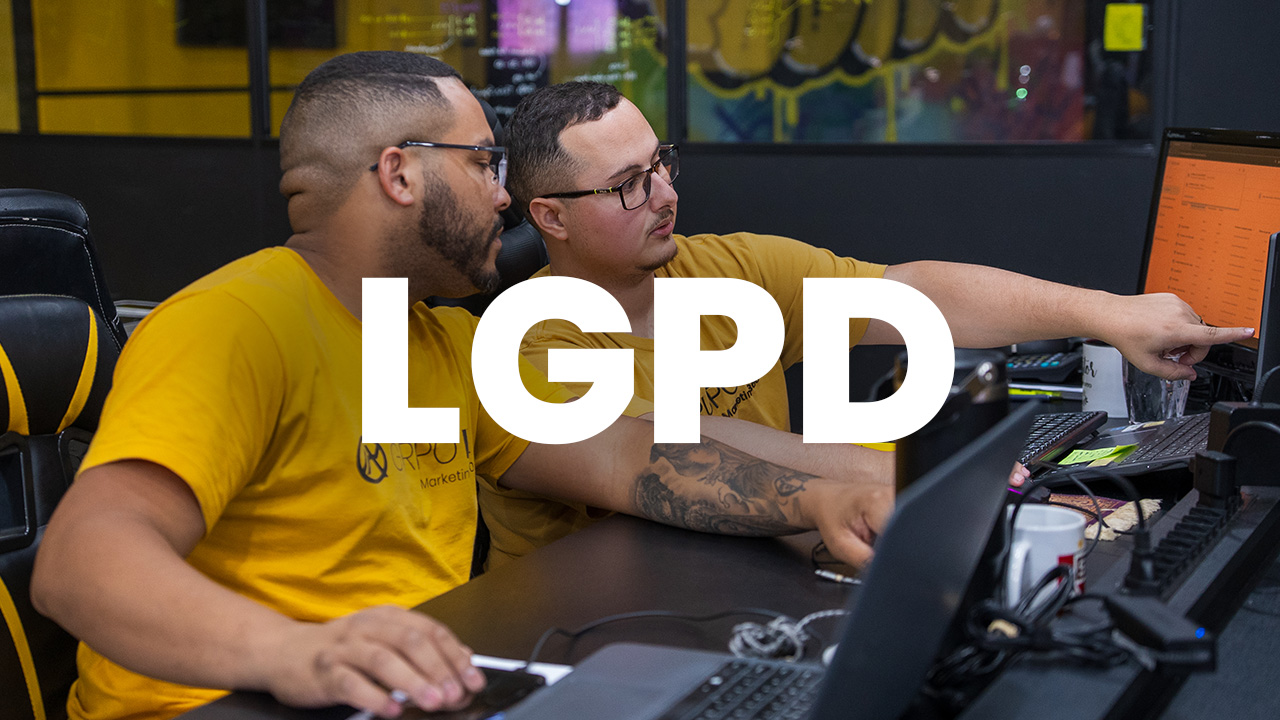 Profissional organizando contatos no celular e computador, representando a aplicação da LGPD para pequenas empresas.